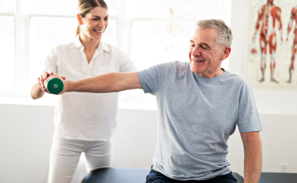 A man recovering from rotator cuff surgery practices physical therapy.