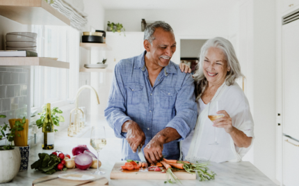 An older couple practices self-care by making a healthy dinner.