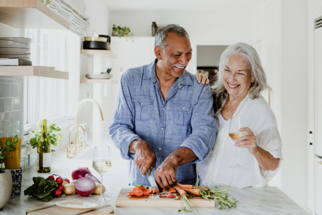 An older couple practices self-care by making a healthy dinner.