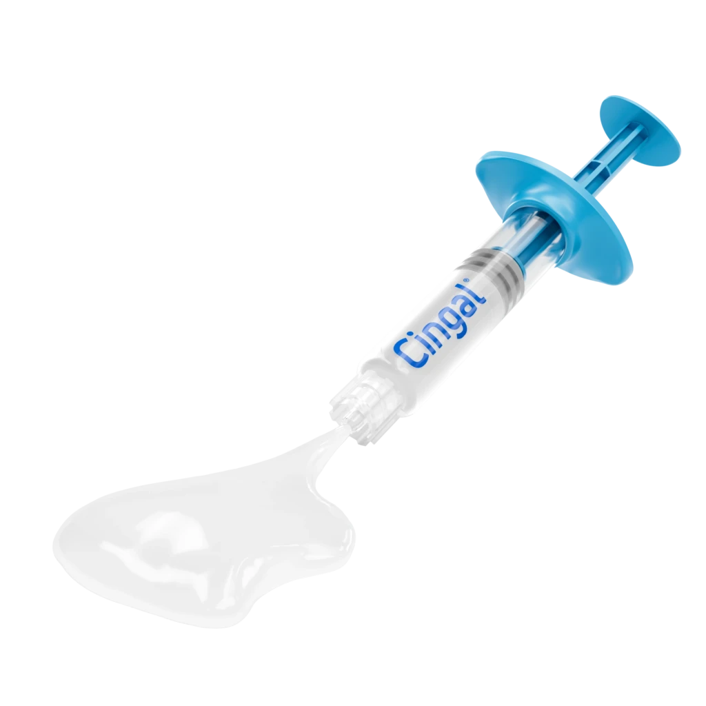 Blue and clear medical syringe with "Cingal" branding, lying at an angle on a white background with shadow reflection.